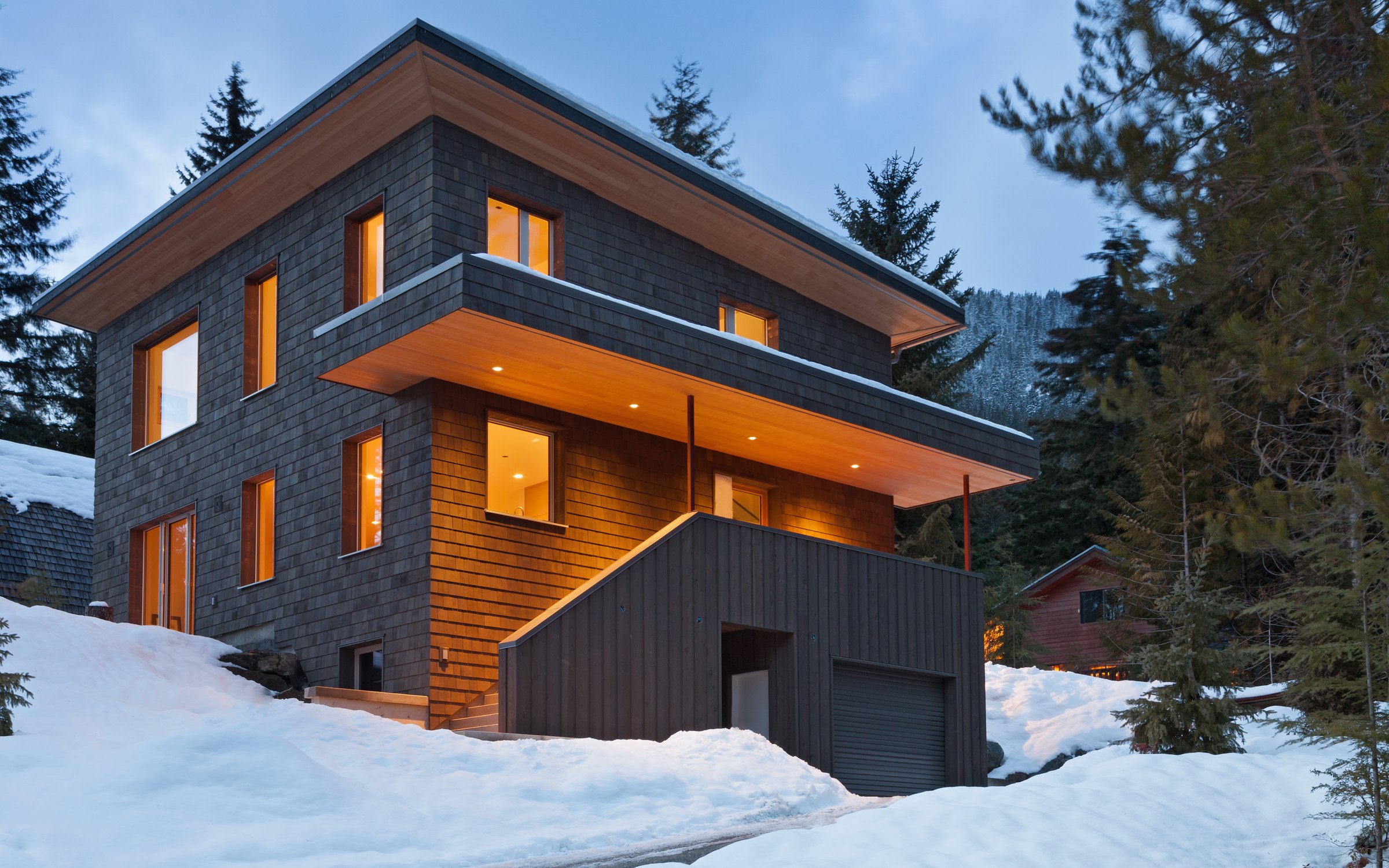 Modern timber home with Optiwin windows in a snowy mountain climate