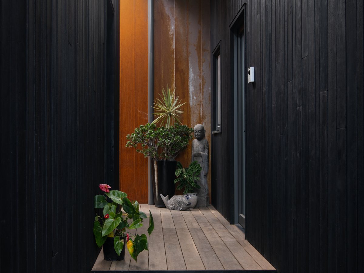 Modern entrance with dark timber facade